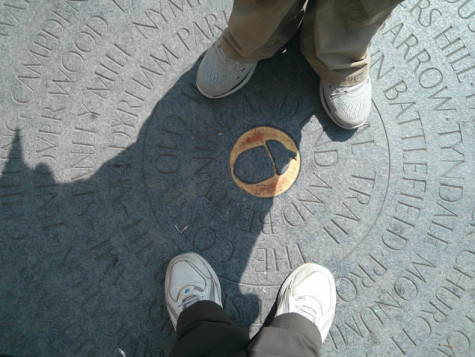 Feet on a marker inscribed with the placenames along the Cotswold Way