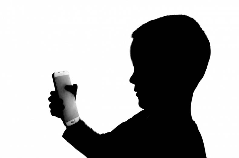 silhouette of child holding smartphone