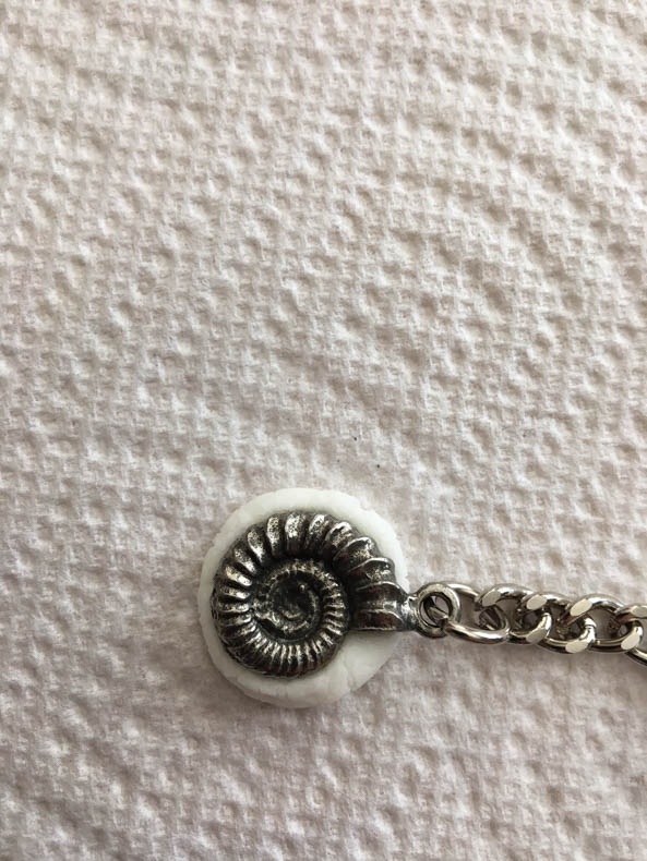 an ammonite-shaped keychain pressed into a mini-marshmallow