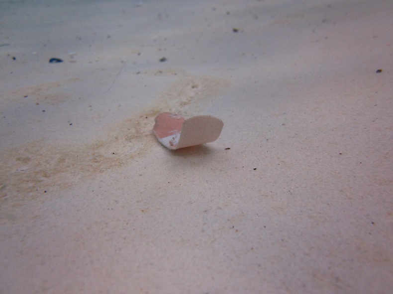 A bandaid on the bottom of a swimming pool.