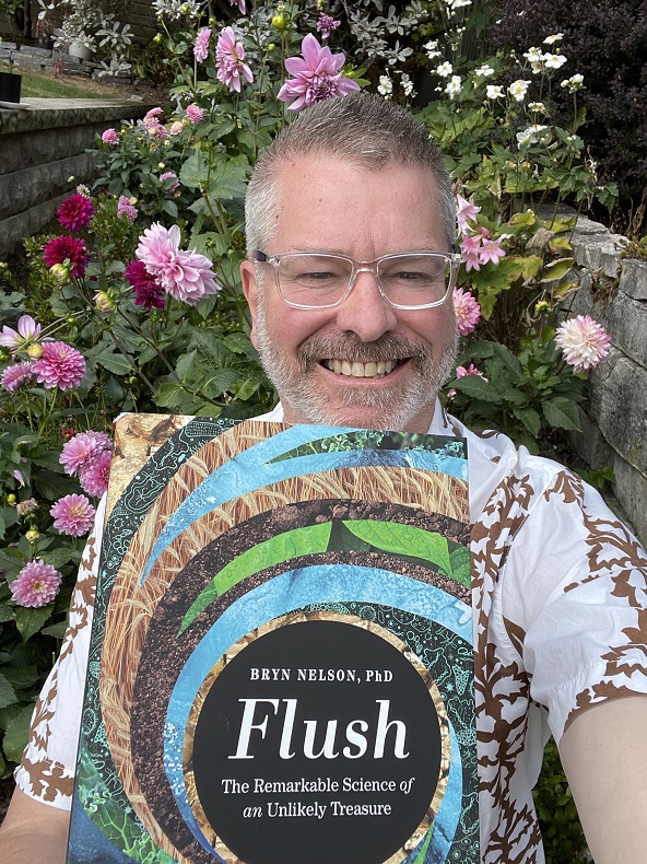 A man with glasses holding the book Flush