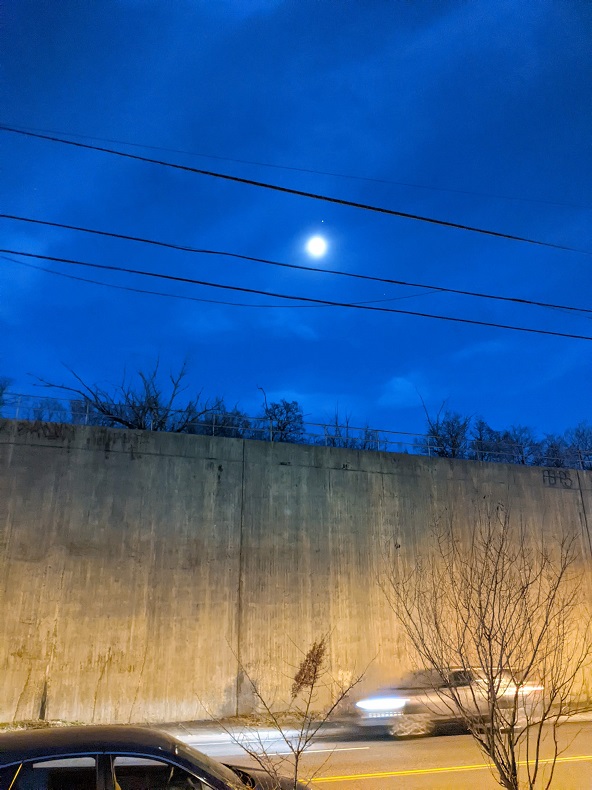 The moon and mars above a tall concrete wall
