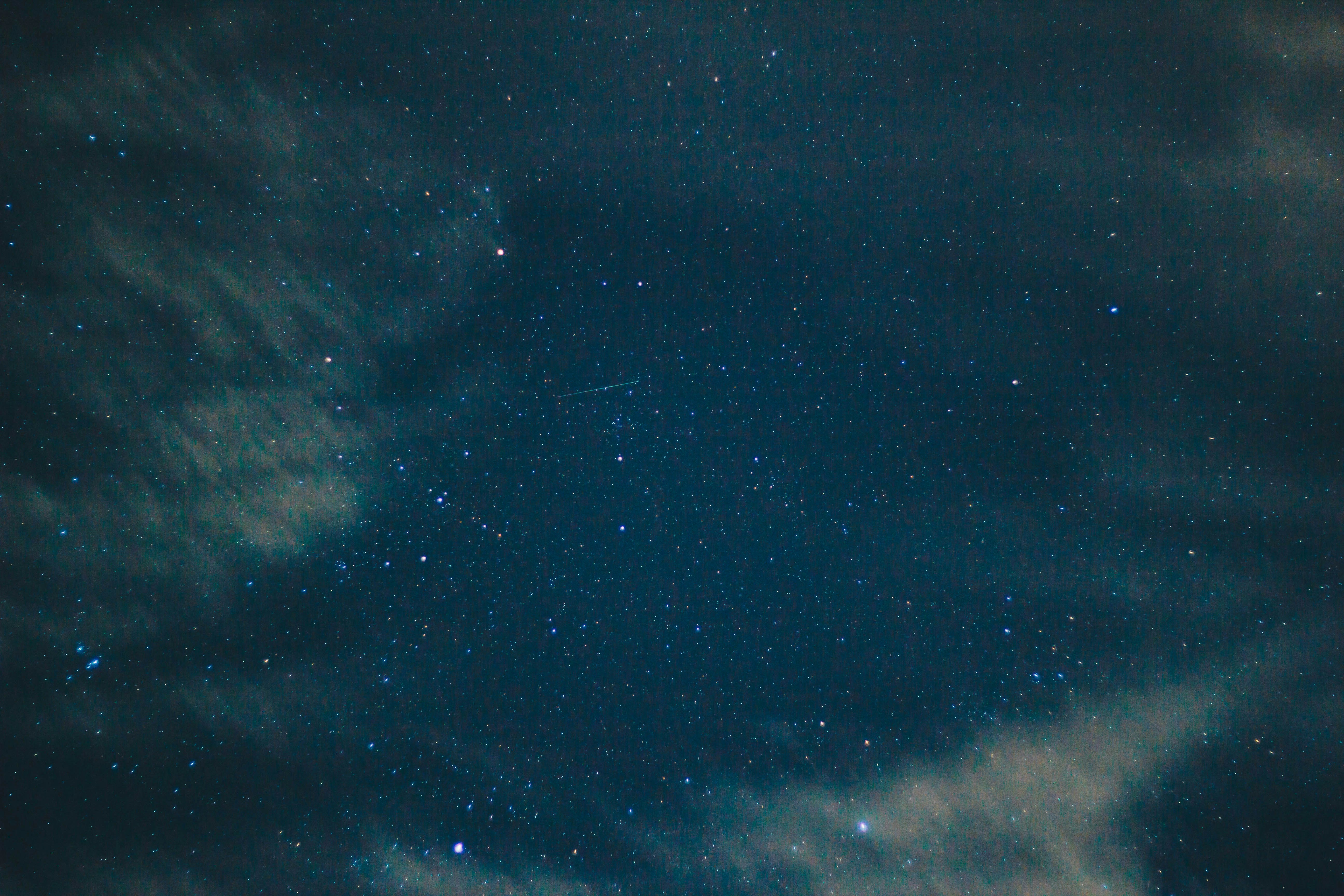 Photograph of a cloudy night sky with a single streak of light